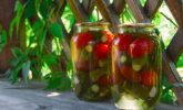 jars-of-pickled-assorted-tomatoes-and-cucumbers-on-the-table-in-a-wooden-gazebo-in-the_t20_WxrxBw