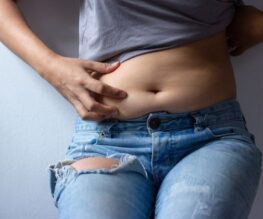 woman-with-overweight-abdomen-hand-holding-excessive-fat-belly-front-view_t20_a7k9eQ